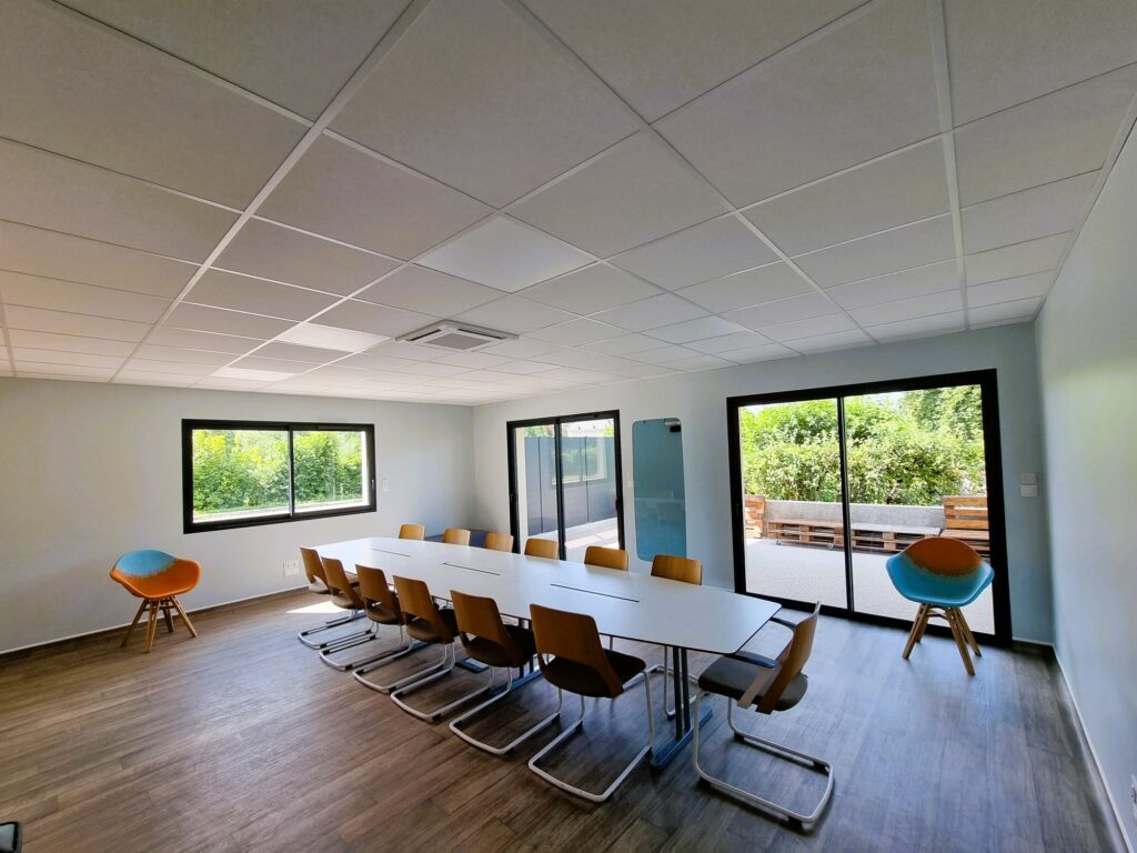 Salle réunion avec une longue table au centre ainsi que des chaises autour